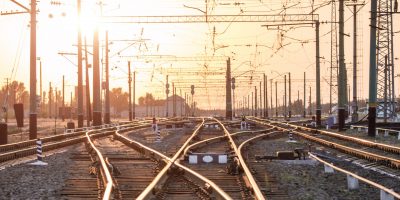 An empty railway sorting station or terminal with lots of juncti An empty railway sorting station or terminal with lots of junction, crossroads, semaphore showing red or green light, in a bright sunset light. The difficulty of finding the right way concept