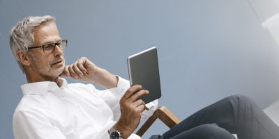 Manager sitting in office, using digital tablet