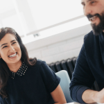 A woman and man smile in the workplace