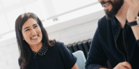 A woman and man smile in the workplace