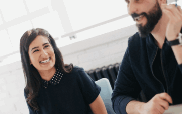 A woman and man smile in the workplace
