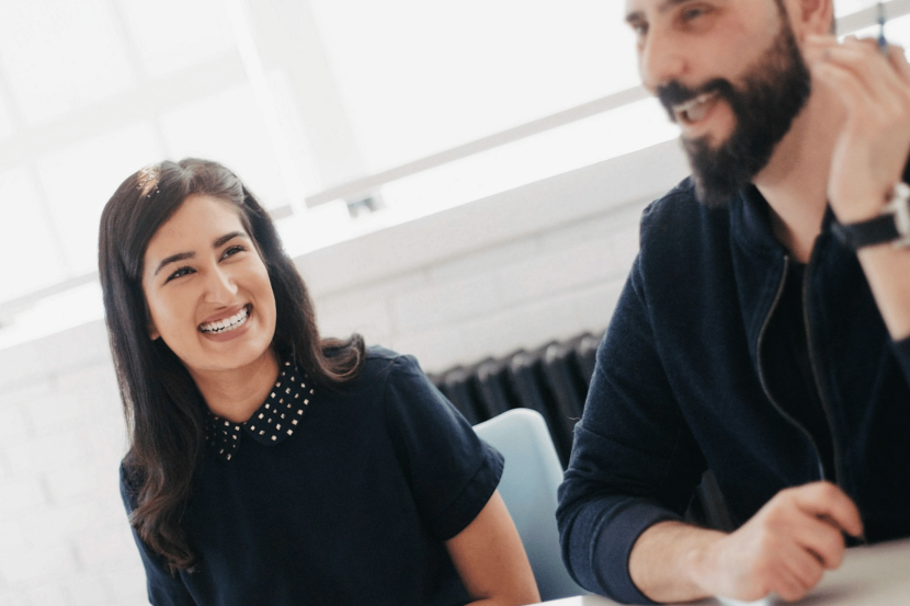 A woman and man smile in the workplace