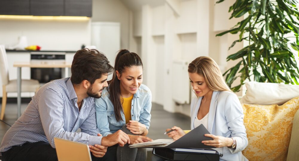 Female Real Estate agent offers home ownership and life insurance to young couple. Female Real Estate agent offers home ownership and life insurance to young couple.